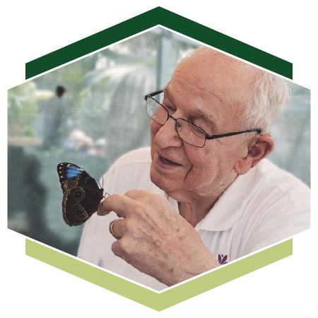 Resident handling butterfly at nature conservatory